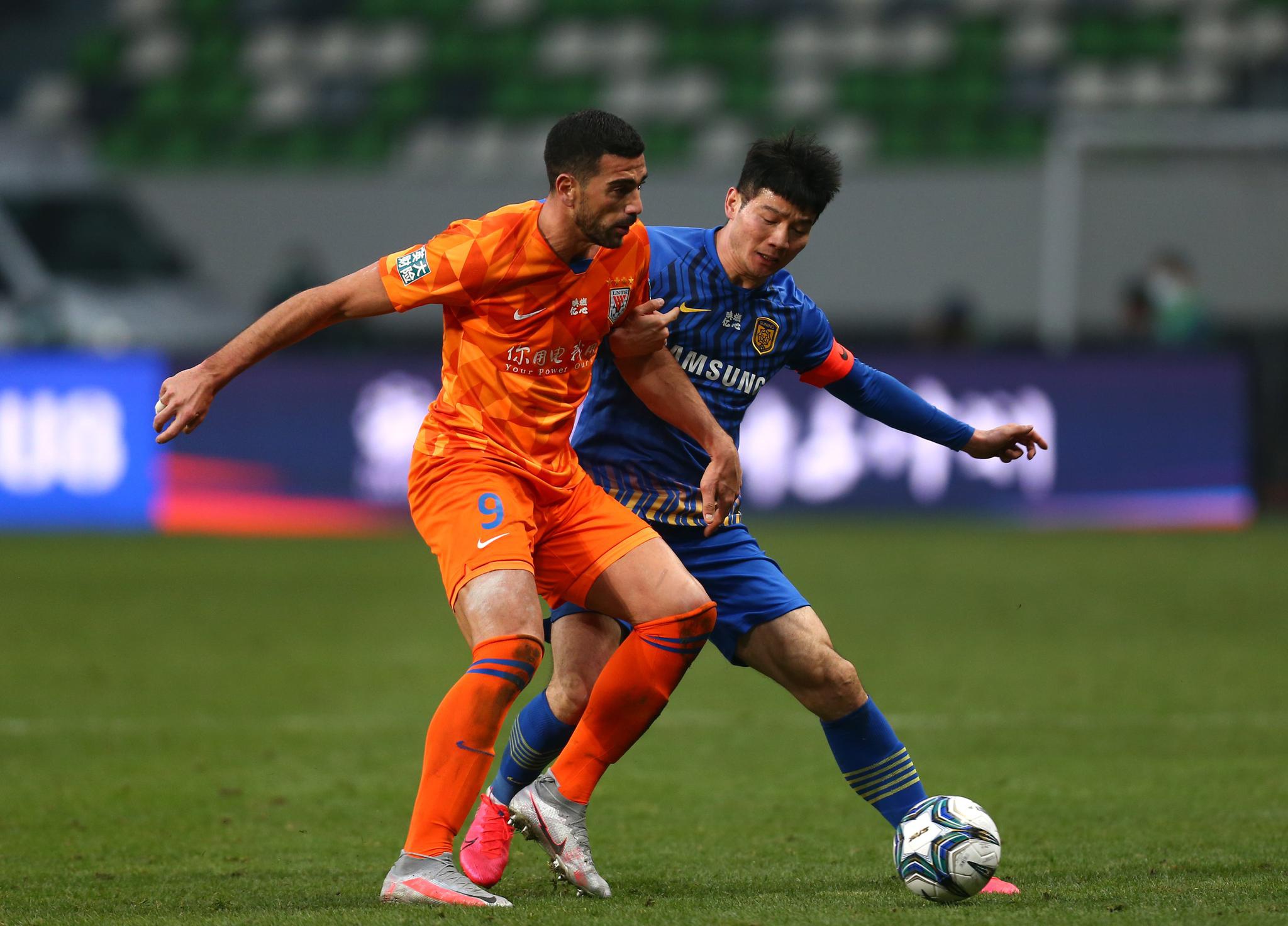 山东鲁能泰山队球员佩莱(左)与江苏苏宁易购队球员吉翔在比赛中拼抢