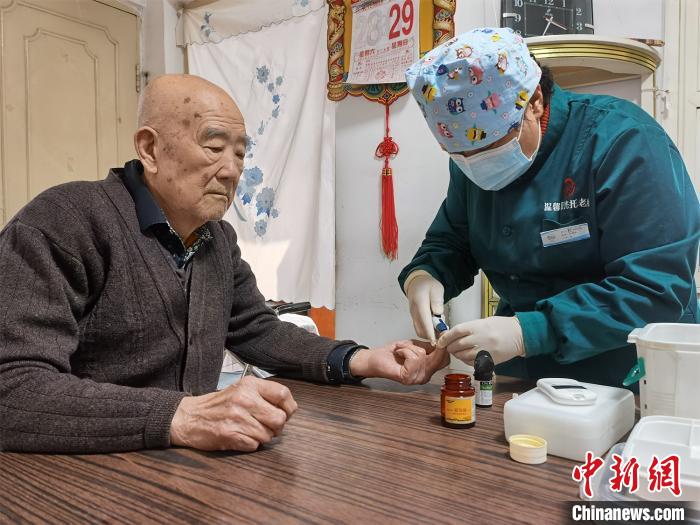 图为工作人员为邓琳父亲测血糖. 祁增蓓 摄