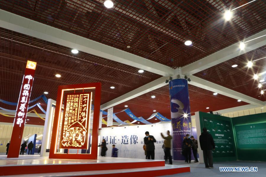 Visitors view photos at a photography exhibition during the 13th China Photography Festival in Sanmenxia City of central China's Henan Province, Dec. 20, 2020. The 13th China Photography Festival kicked off on Dec. 20 in the city of Sanmenxia in central China's Henan Province. This year's festival carries the theme of the country's fight against poverty and the COVID-19 epidemic. (Xinhua/Xu Yanan)