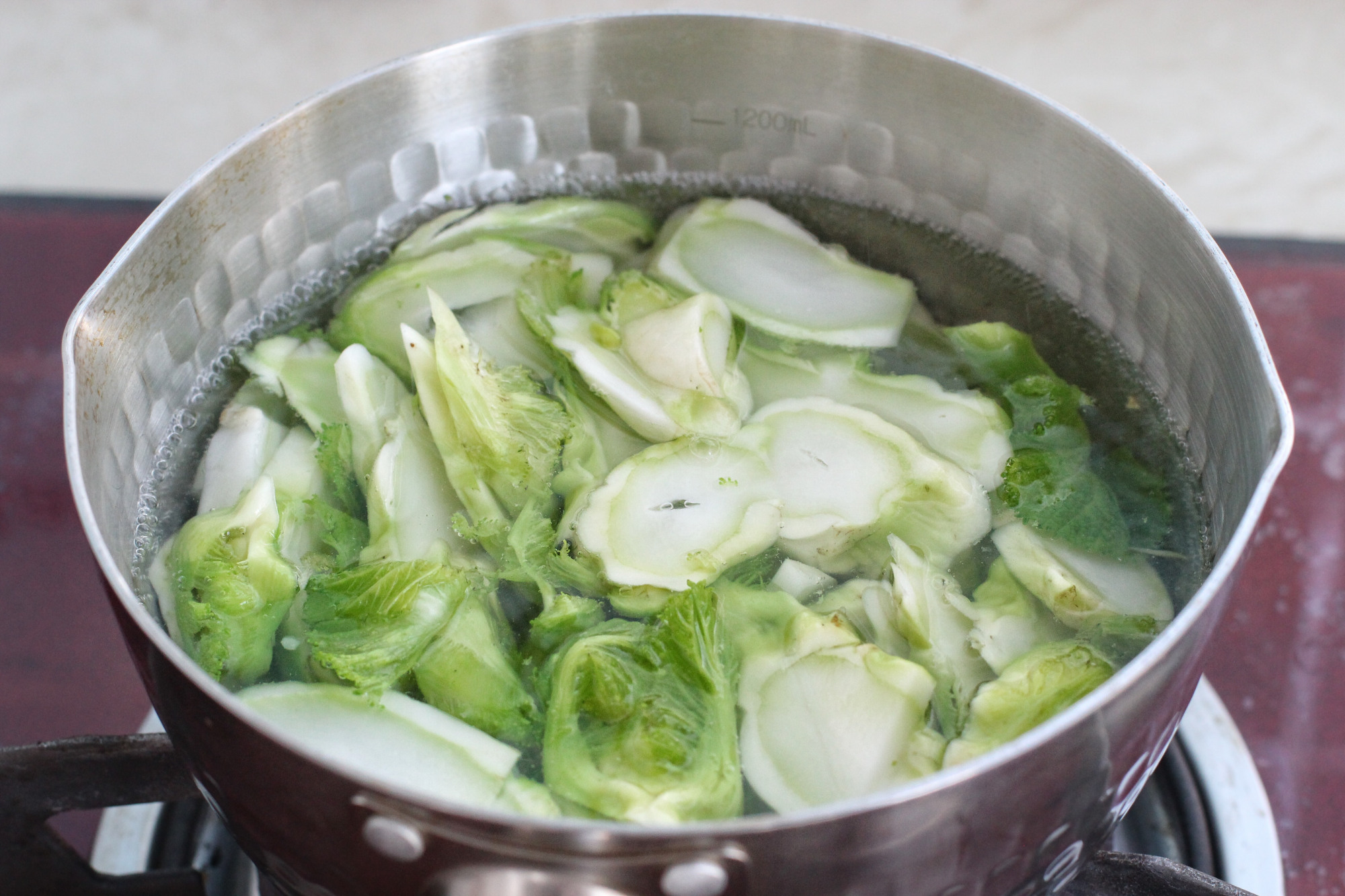 锅中烧开水,先下入儿菜的茎焯烫三十秒,再下入叶子烫三十秒,捞出过