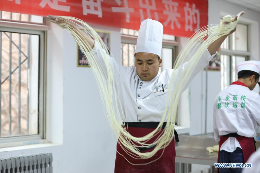 A trainee practices making hand-pulled noodles at a vocational school in Dongxiang County of Linxia Hui Autonomous Prefecture, northwest China's Gansu Province, May 28, 2020. China has made great achievements in poverty relief that has impressed the world, with almost 100 million people lifted out of poverty. (Xinhua/Ma Xiping)