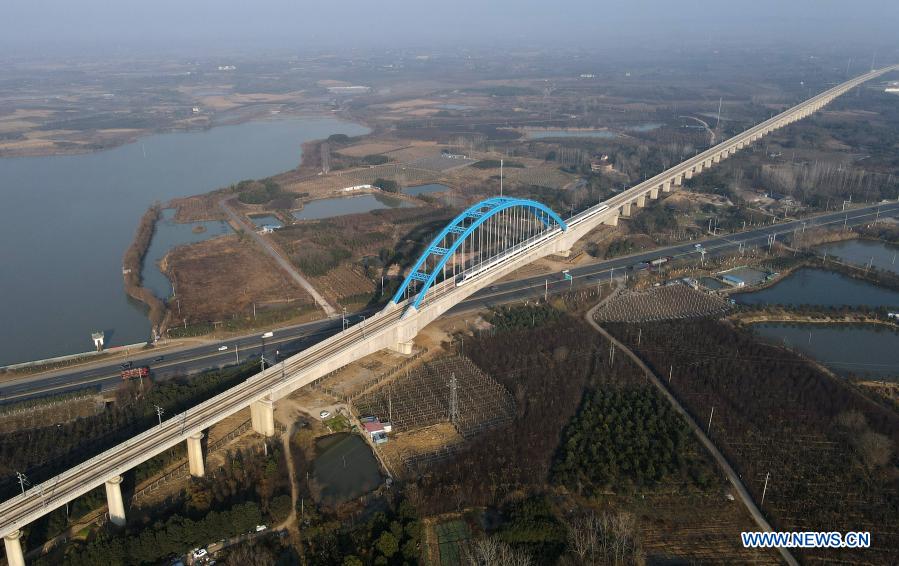 Aerial photo taken on Dec. 22, 2020 shows a high-speed train passing through the Huagang super major bridge along the Hefei-Anqing section of the Beijing-Hong Kong high-speed railway in Feixi County of east China's Anhui Province. The Hefei-Anqing section of the Beijing-Hong Kong high-speed railway was put into operation Tuesday. Cities of Hefei and Anqing, both in Anhui Province, are critical hubs where several other major railway tracks intersect. The 176-kilometer section of tracks allow trains to run at a designed speed of 350 kilometers per hour on them. (Xinhua/Liu Junxi)