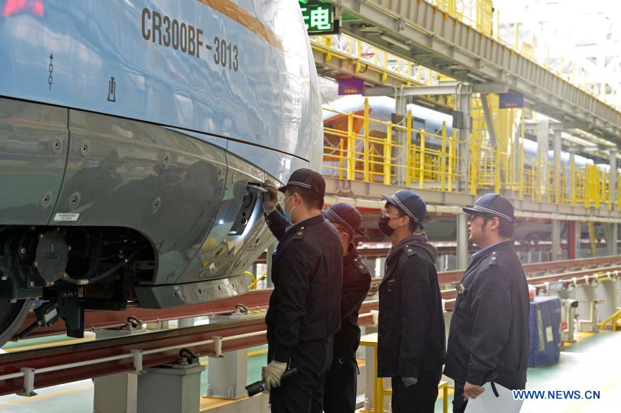 Staff members examine a bullet train in Yinchuan, northwest China's Ningxia Hui Autonomous Region, on Dec. 23, 2020. Three sets of Fuxing bullet trains that will be put into service on the railway linking Yinchuan and Xi'an, arrived in Yinchuan. (Xinhua/Tang Rufeng)