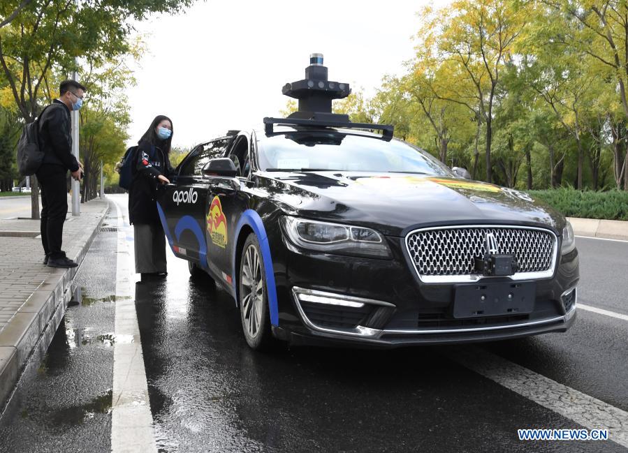 A woman takes a self-driving taxi at an appointed location on the Daoxianghu Road in Haidian District of Beijing, capital of China, Oct. 14, 2020. With the development of new technologies such as the 5G, artificial intelligence and BeiDou Navigation Satellite System (BDS), unmanned technology is injecting impetus into traditional industries as well as making people's life easier and more convenient in China, and bringing about profound innovation and transformation. From commerce, agriculture, transportation, industrial production to environmental protection, China has been embracing this emerging technology in various fields in recent years as it strives to promote high-quality development. (Xinhua/Ren Chao)