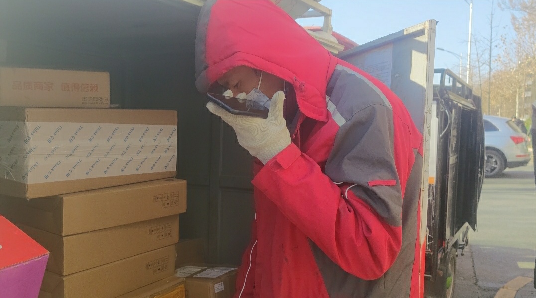 快递员王伟正打电话询问客人快递如何处理