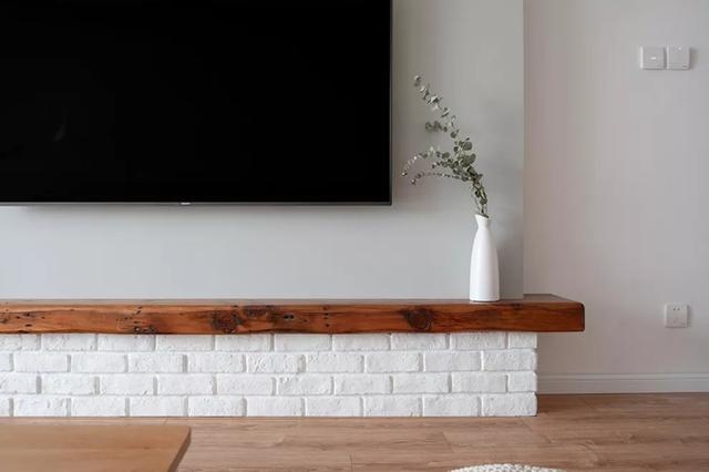 电视柜是砖砌成的,简单的粉刷搭配原木板很有层次感.