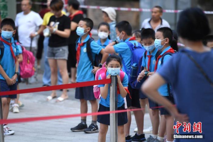 资料图：9月1日，重庆市大渡口区双山实验小学的学生们戴着口罩有序进入校园。 中新社记者 陈超 摄
