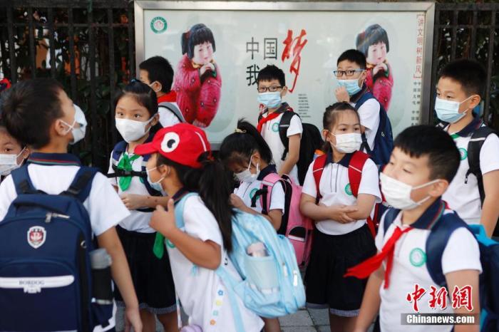 资料图：9月1日，上海市华博利星行小学门口，学生戴着口罩依次排队等待进入学校。 中新社记者 殷立勤 摄