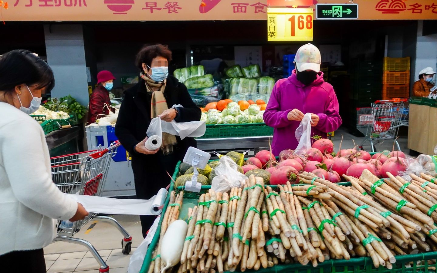 物美超市惠新店，几位顾客抽取连卷袋。一位店员介绍，店里的连卷袋消耗量非常大，差不多每半个月就得拉一车来。摄影/新京报记者 李凯祥