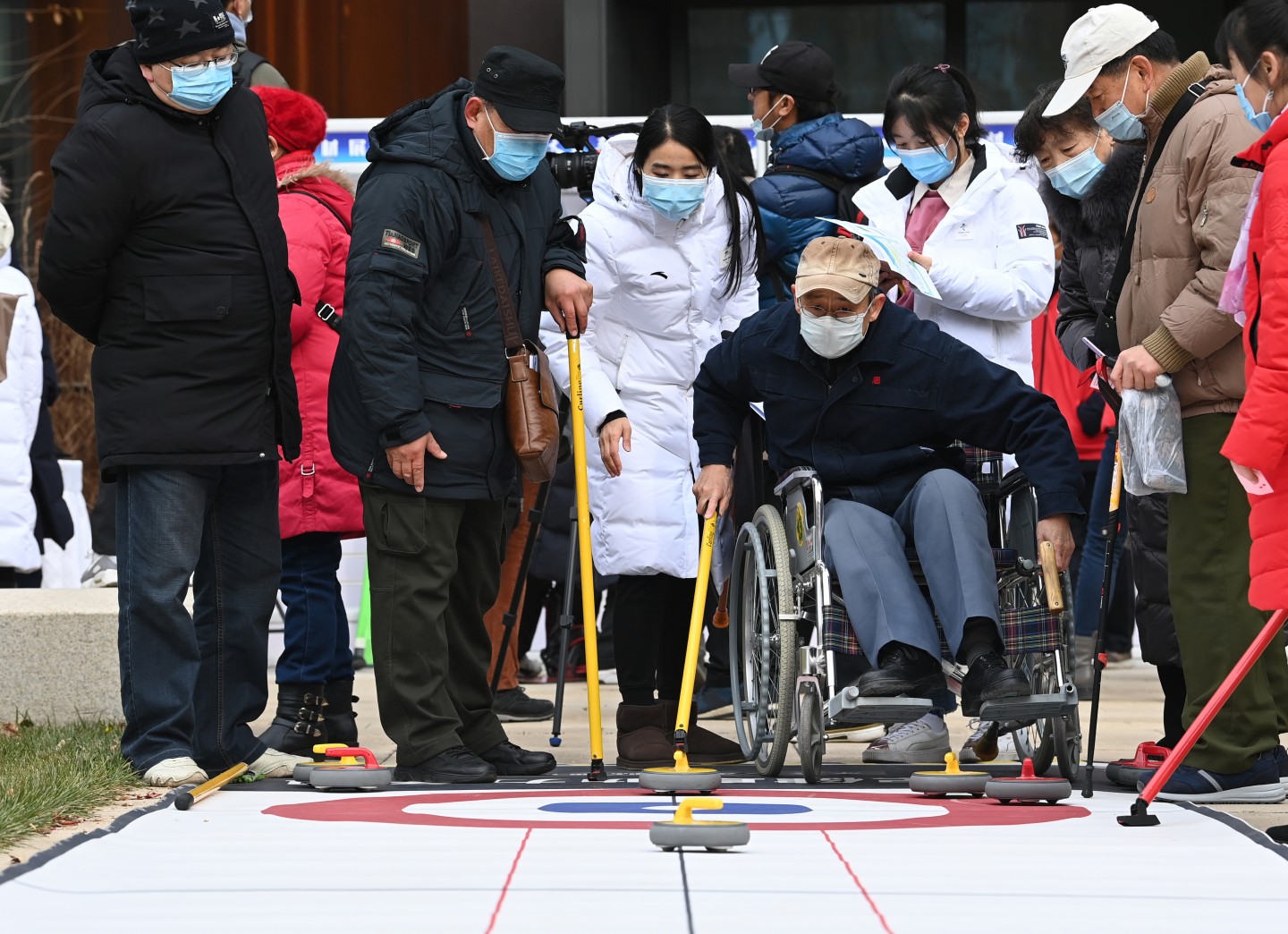 12月2日，来自北京市基层社区的残疾人及亲属，与冬残奥会冠军、北京冬奥组委青年团员一起开展了旱地冰球、桌上冰壶、陆上冰壶、冰蹴球和雪上项目VR体验等趣味冰雪活动。新京报记者 陶冉 摄