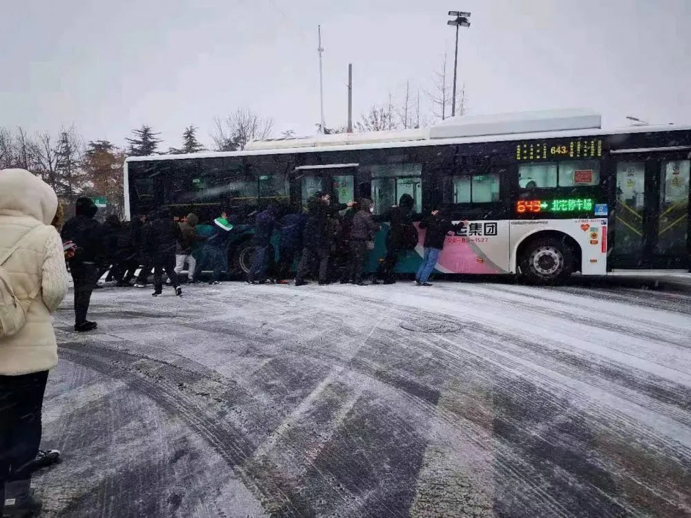 暖闻丨青岛近百名乘客雪天推公交车上坡，公司备百份礼物致谢