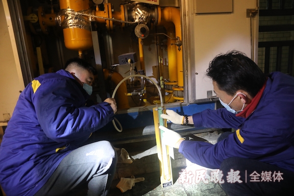 图说:燃气工作人员使用u形管子测量燃气箱式调压站压力是否正常 新民