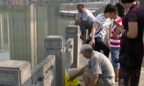 大妈河边放生一百多条鱼，但旁边大爷的做法，让她感到无奈和气愤休闲区蓝鸢梦想 - Www.slyday.coM