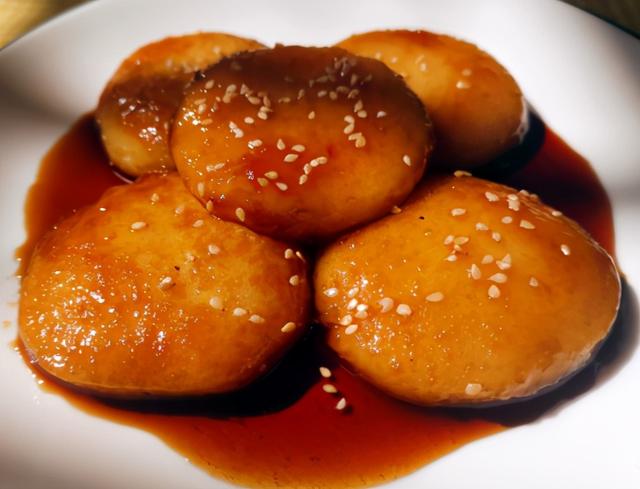 大火将红糖水煮开后,转至小火,放入煎过的糯米糍粑,小火慢慢熬煮;第三