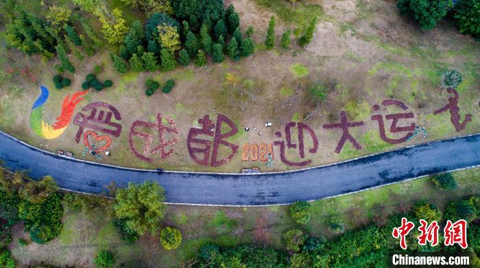 环卫工人用落叶在凤凰湖拼出“爱成都”“迎大运”等字样。　白桂斌 摄
