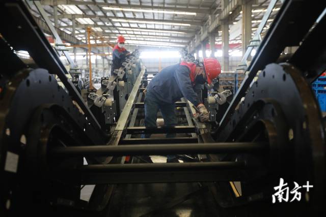 东莞快意电梯的生产车间，技术人员戴着口罩在进行电梯的组装。