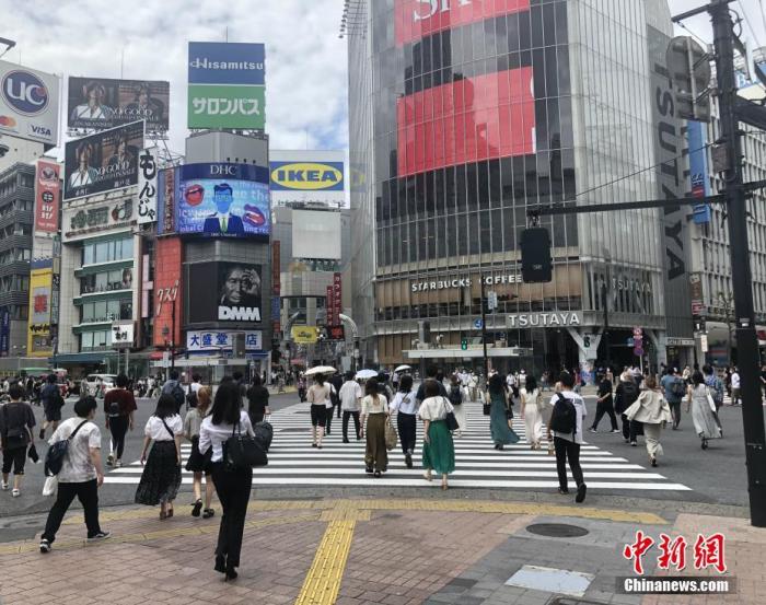 图为民众穿过日本涩谷车站前的交叉路口。 中新社记者 吕少威 摄