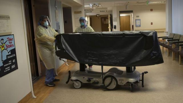 加州医疗中心，医护人员带着一名新冠患者的尸体进入电梯
