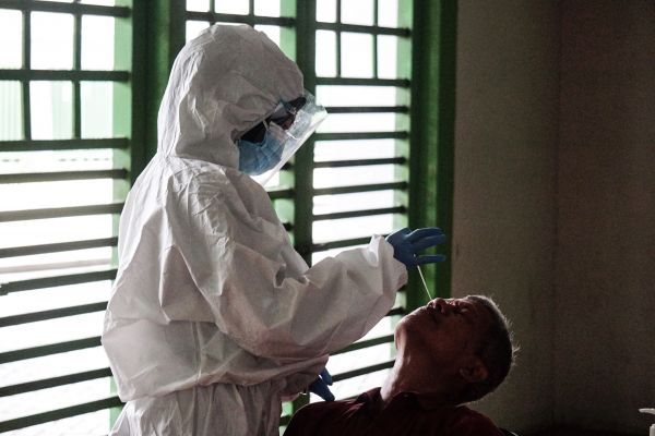  在印度尼西亚勿加泗，一名医护人员采集新冠病毒检测样本。（新华社）