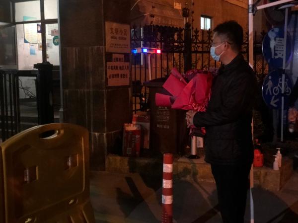 2020年23时30分许,上海浦东新区祝桥镇航城七路450弄小区门口,马杰抱着一束玫瑰打算送给小区内的妻子。本文图片均为澎湃新闻记者 邹娟 摄