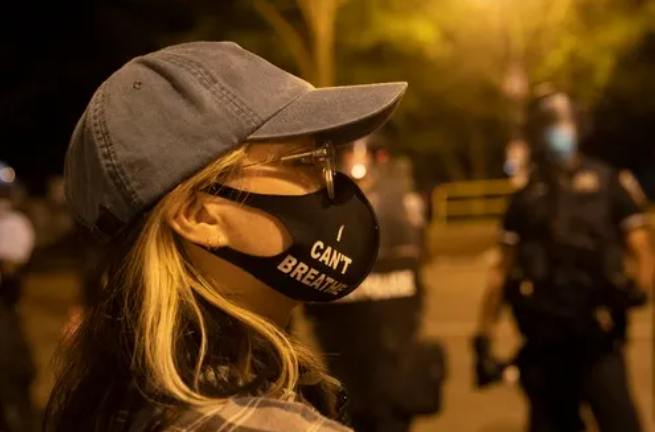 6月22日,一名女子戴着写有"我不能呼吸"的口罩在美国华盛顿白宫附近