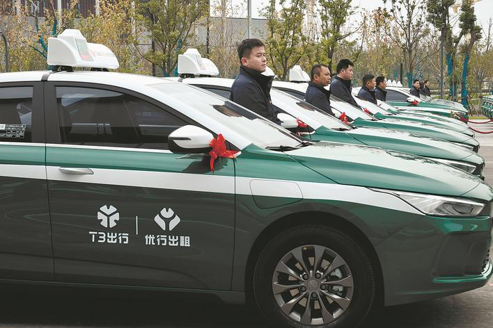 记者黄哲绿白配色的流线型车身,"t3出行""优行出租"标志在车顶灯和