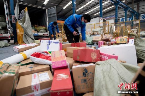 原料图:2月20日,山西省太原市,在中通快递山西转运中央,员工戴着口罩分拣包裹。中新社记者 韦亮 摄