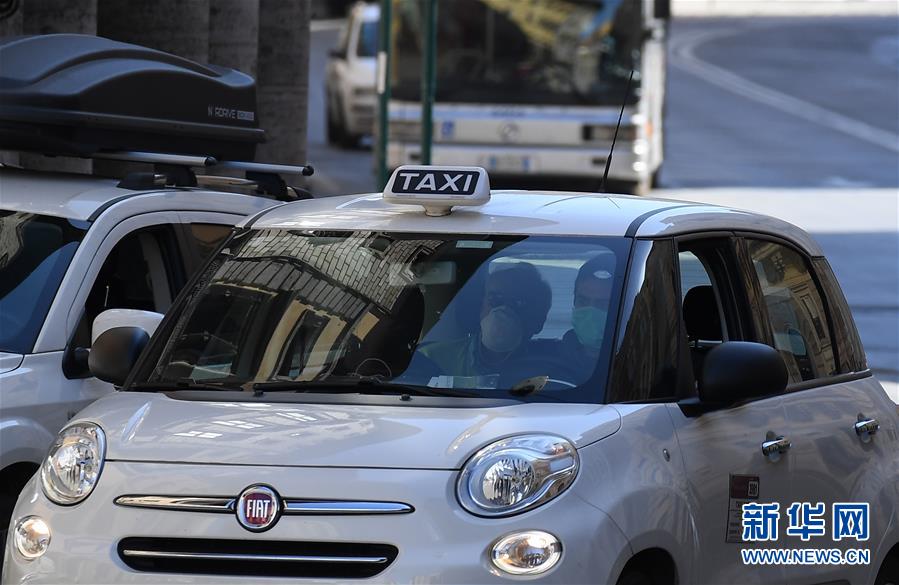 3月12日,在意大利首都罗马,人们戴口罩乘坐出租车.