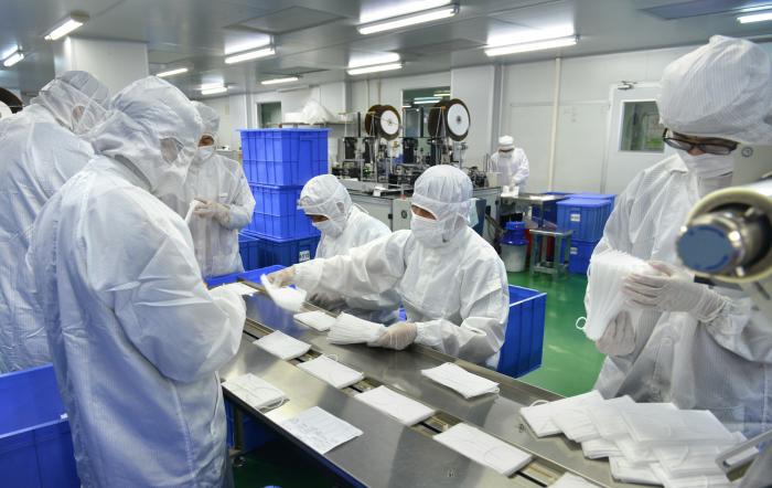 图片1：久林吉良公司员工在口罩生产线上进行生产（公司供图）
