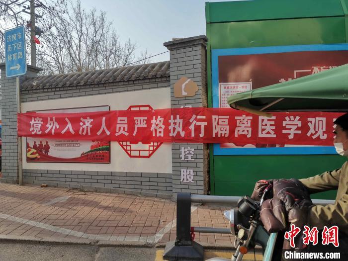 资料图:图为济南街头悬挂"境外入济人员严格执行隔离医学观察"的横幅.