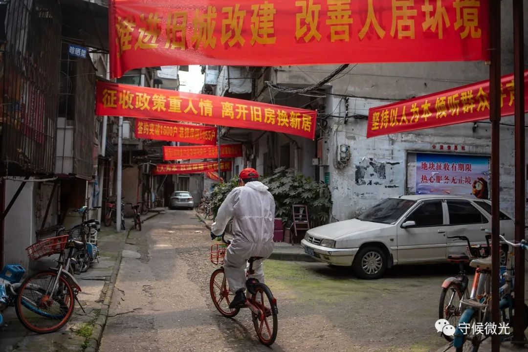3月24日,武汉市大董社区,一名下沉干部骑着共享单车穿行在社区里。中青报·中青网记者李隽辉/摄
