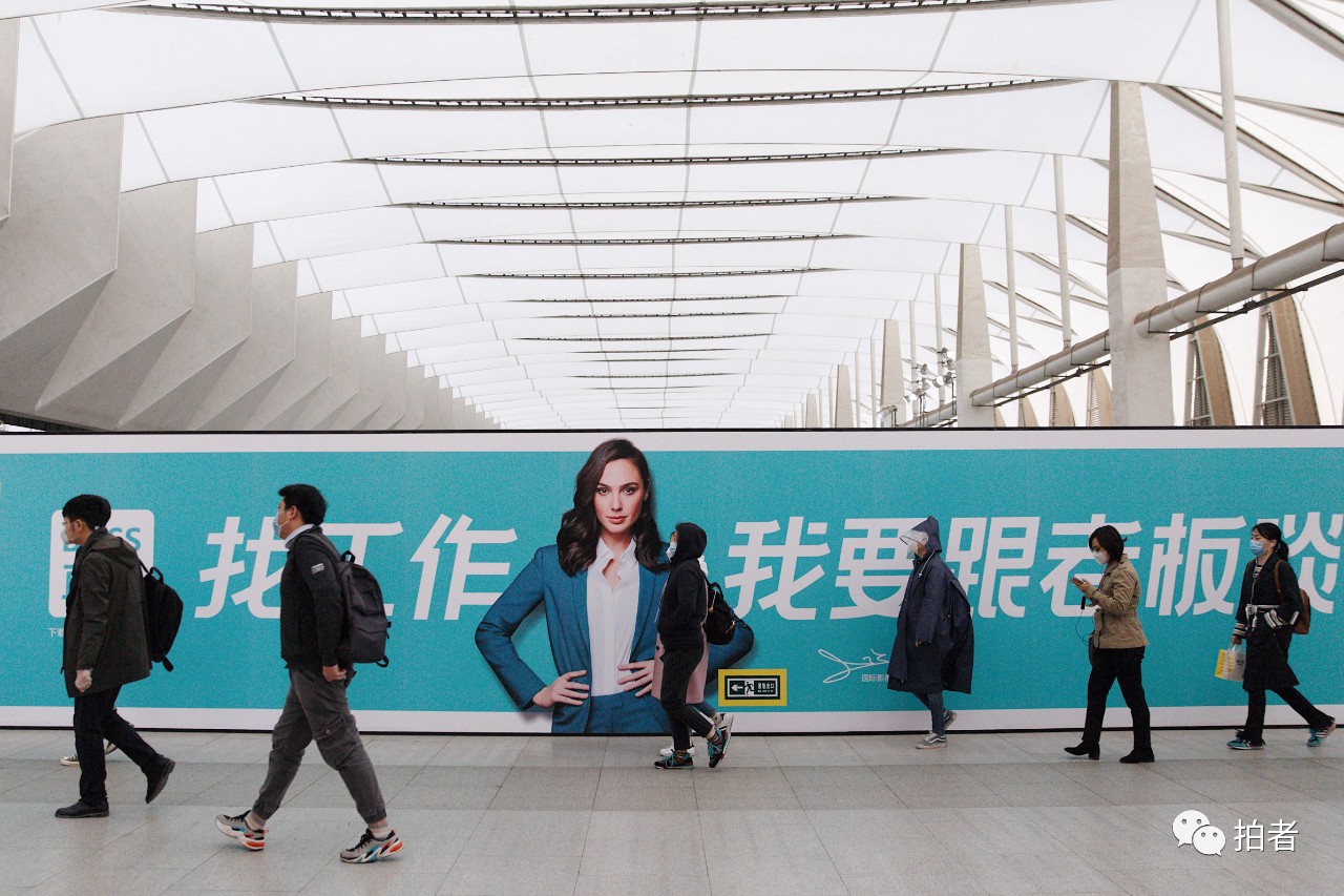 △3月24日,西二旗地铁站,乘客走过站内招聘广告牌。