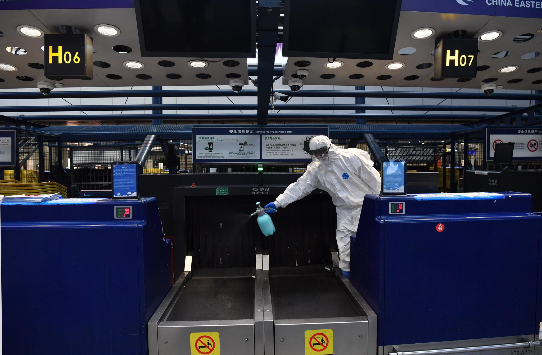为旅客办理完手续后,队员对值机柜台和行李传送带消毒.