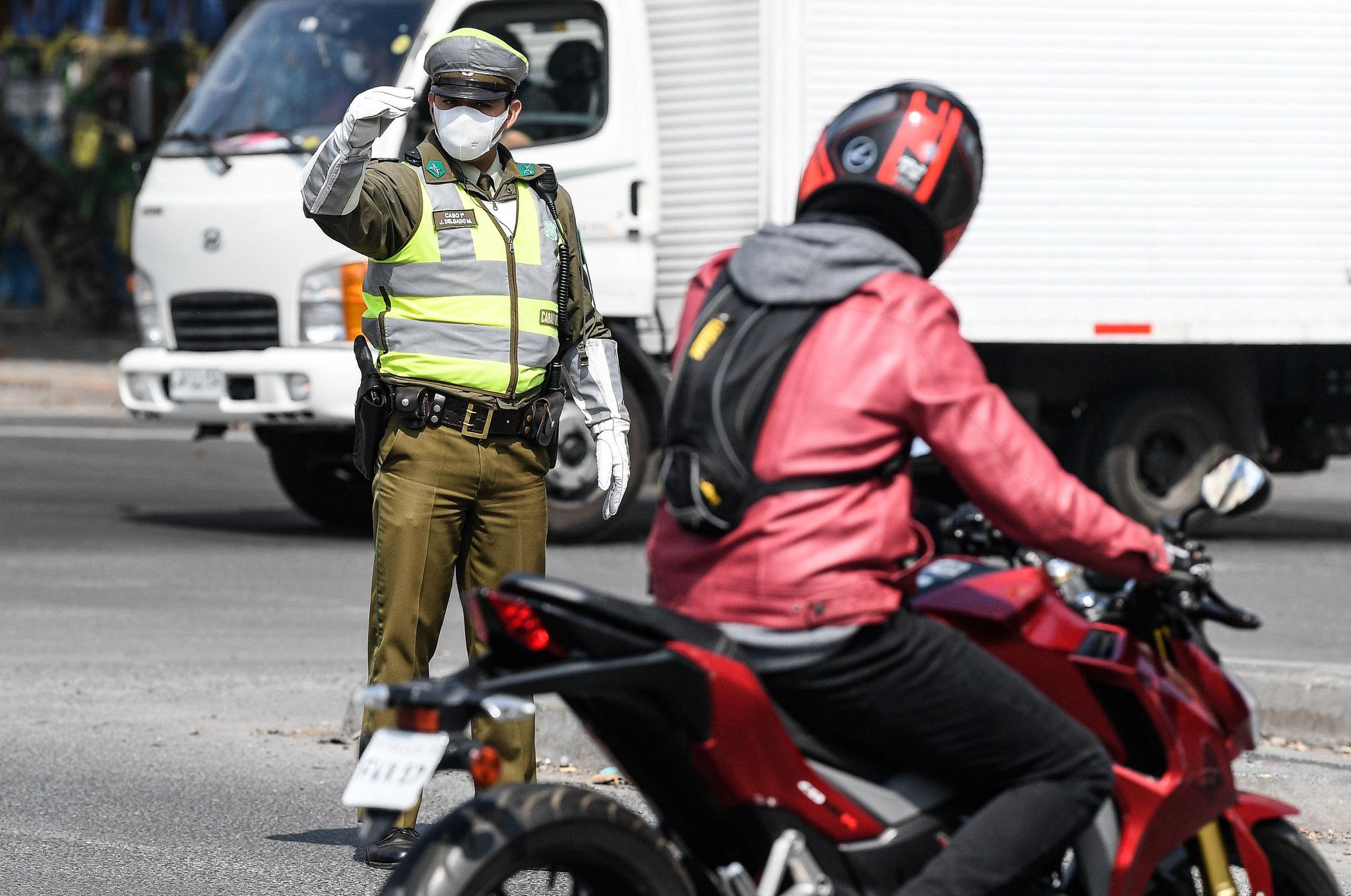3月27日,在智利首都圣地亚哥,军人和警察在街头查验司机出行许可.