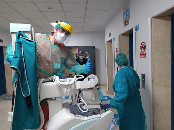 3月26日，在西班牙马德里拉蒙-卡哈尔医院，医务人员正在为患者准备胸部透视检查（手机拍摄）。新华社 图