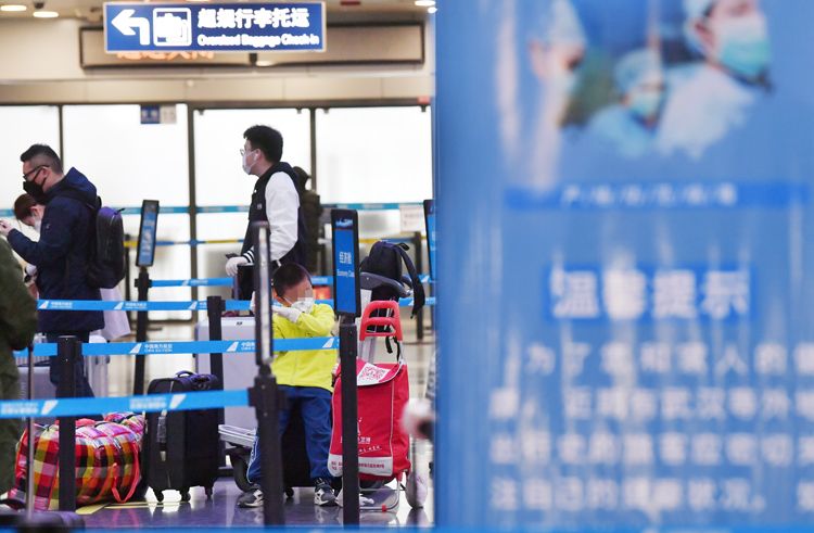 一名小旅客等待家长托运行李。