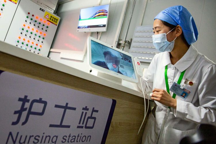 北京小汤山医院新建病区，护士正和病房中的待筛查人员视频通话。