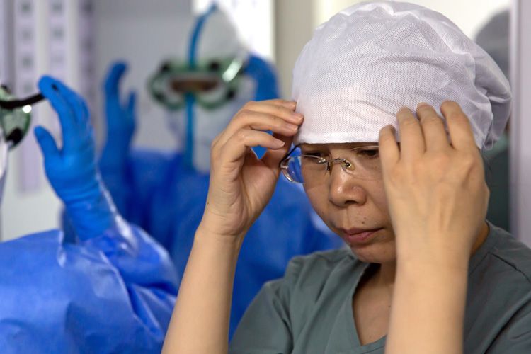 北京小汤山医院B区的防护服穿戴间内，一名护士正在穿防护服。