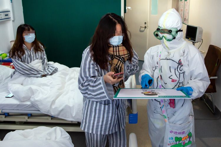 北京小汤山医院B区隔离病房，护士使用中英文对照表与患者沟通。