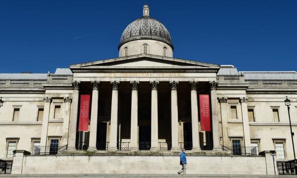 关闭中的英国国家美术馆，一位戴着口罩的行人走过冷清的门口。