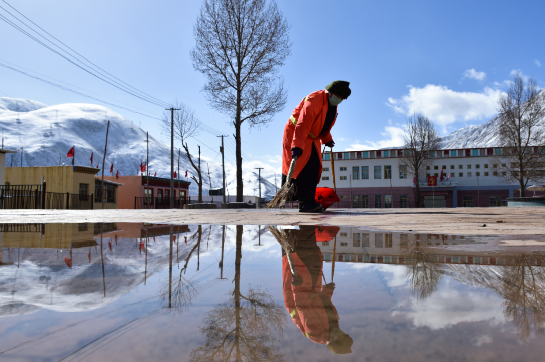 4月6日,一名环卫工人在玉树市扎西大同村的广场清扫垃圾.