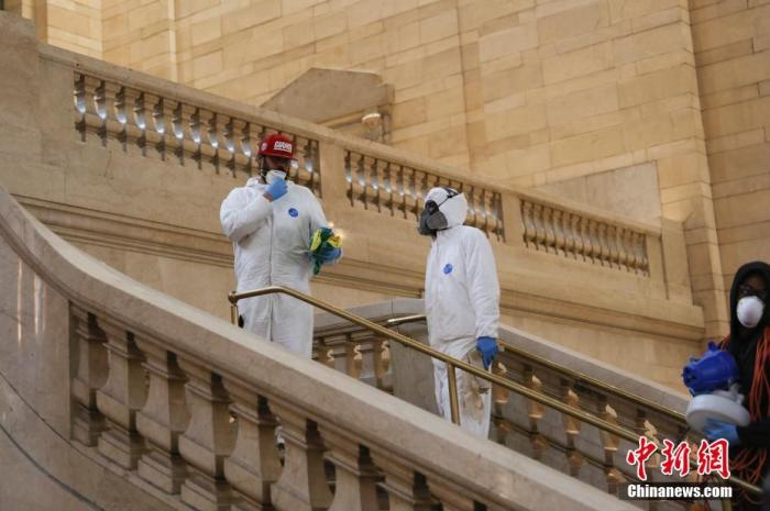 资料图：当地时间4月12日，西方传统节日复活节，纽约中央车站的工作人员防护严密。 中新社记者 廖攀 摄