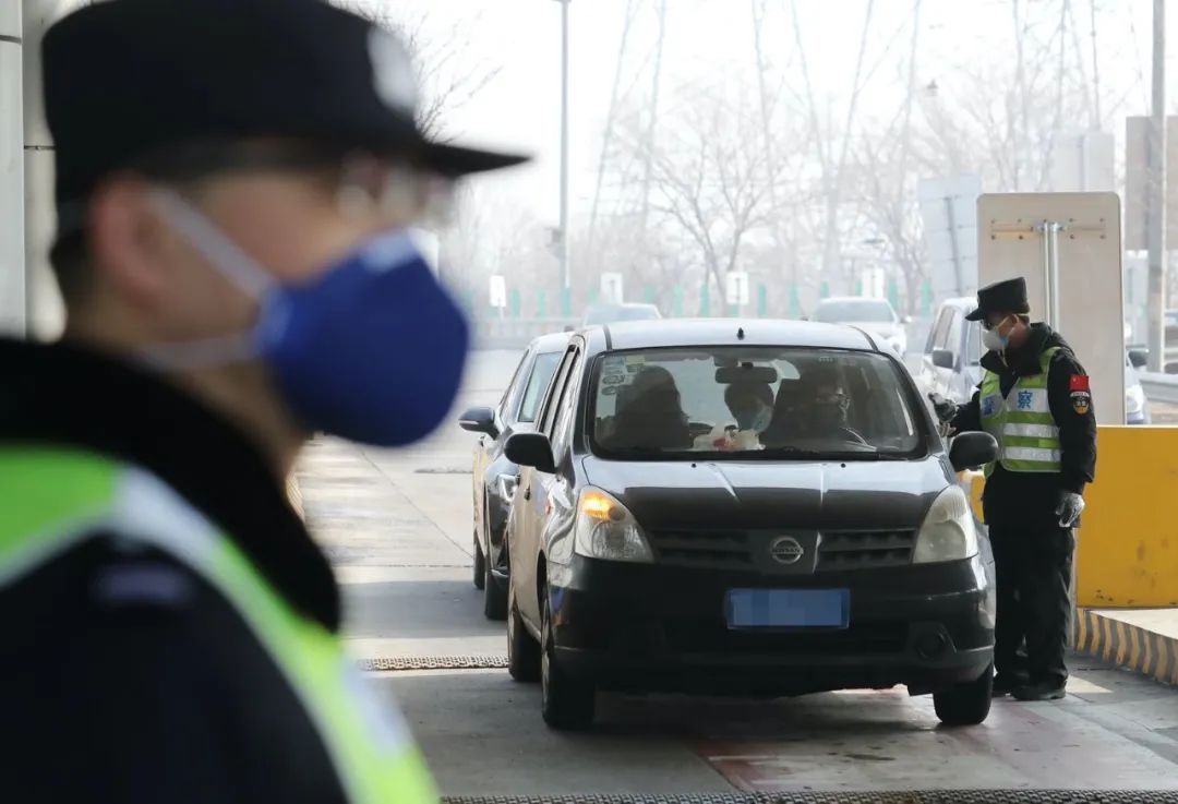  通燕高速白庙进京检查站，民警对进京车辆内的人员核查身份证并测量体温。新京报记者 王贵彬 摄