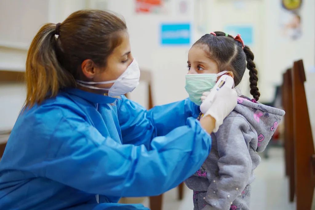 儿基会图片 | 黎巴嫩贝鲁特一家初级卫生保健中心，护士在疫情期间为一名女孩测量体温