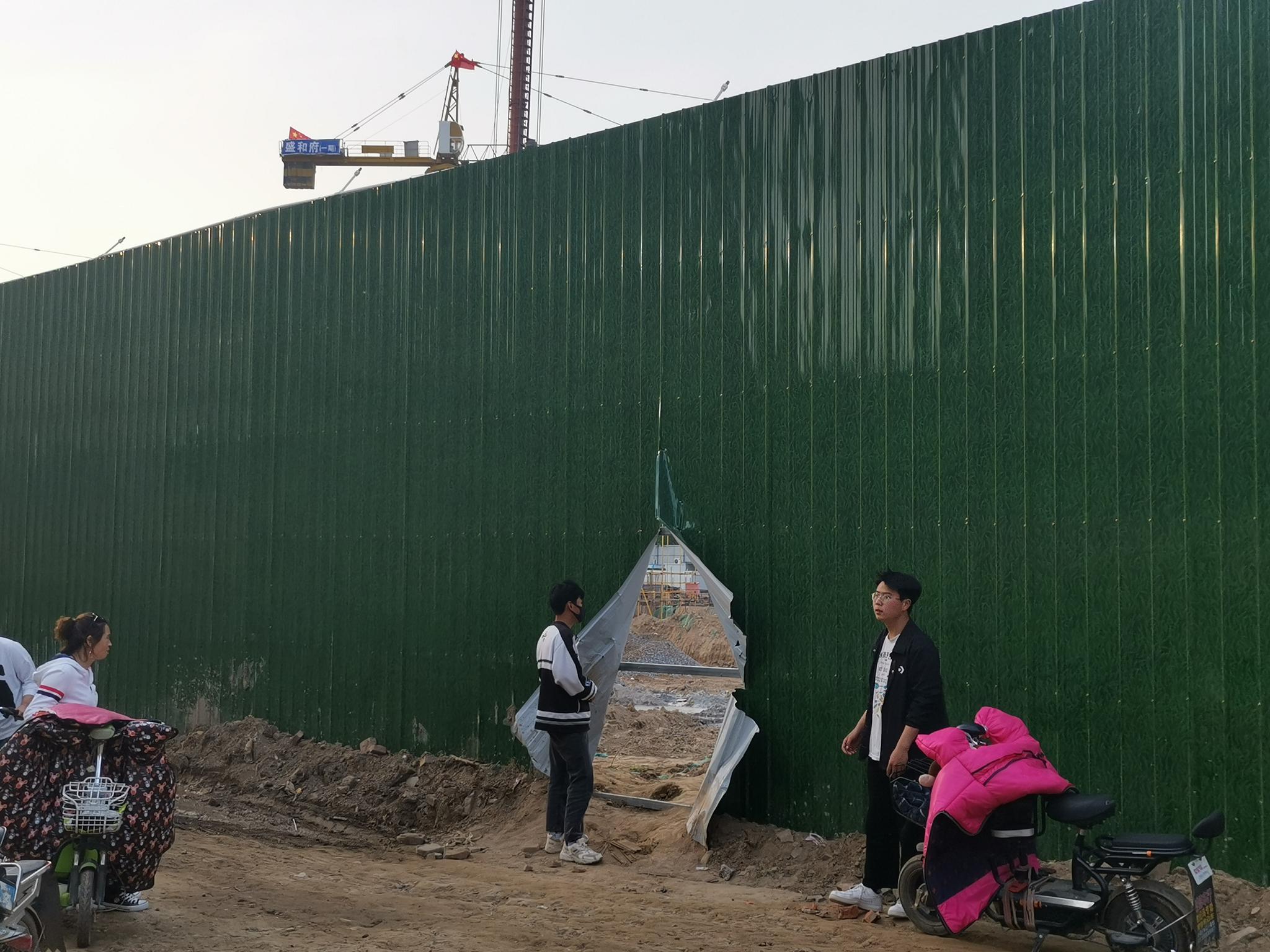 盛和府项目工地南侧通往温庄村的一处围挡破开了大洞。村民称，事发前破口较小，但人也可钻入。新京报记者 雷燕超 摄