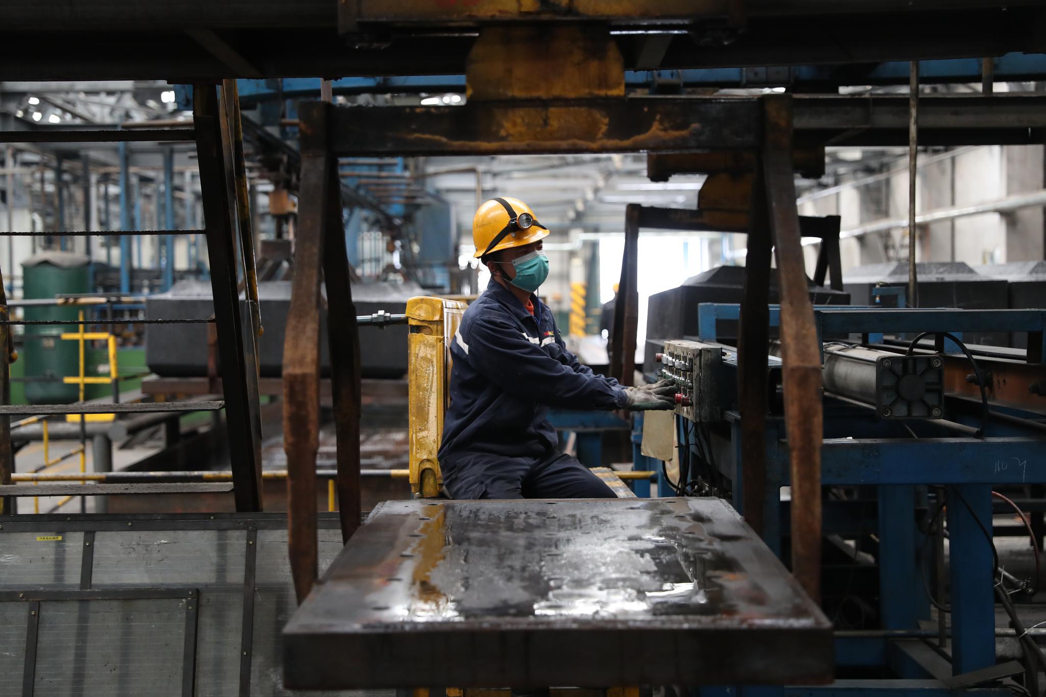 3月31日,在嘉峪关索通公司成型车间内,工人在操作机械作业.