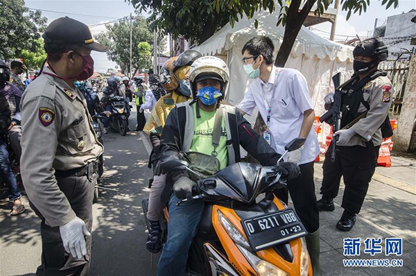 4月22日，在印度尼西亚万隆，驶过检查站的摩托车接受检查。 本文图均为 新华网 图