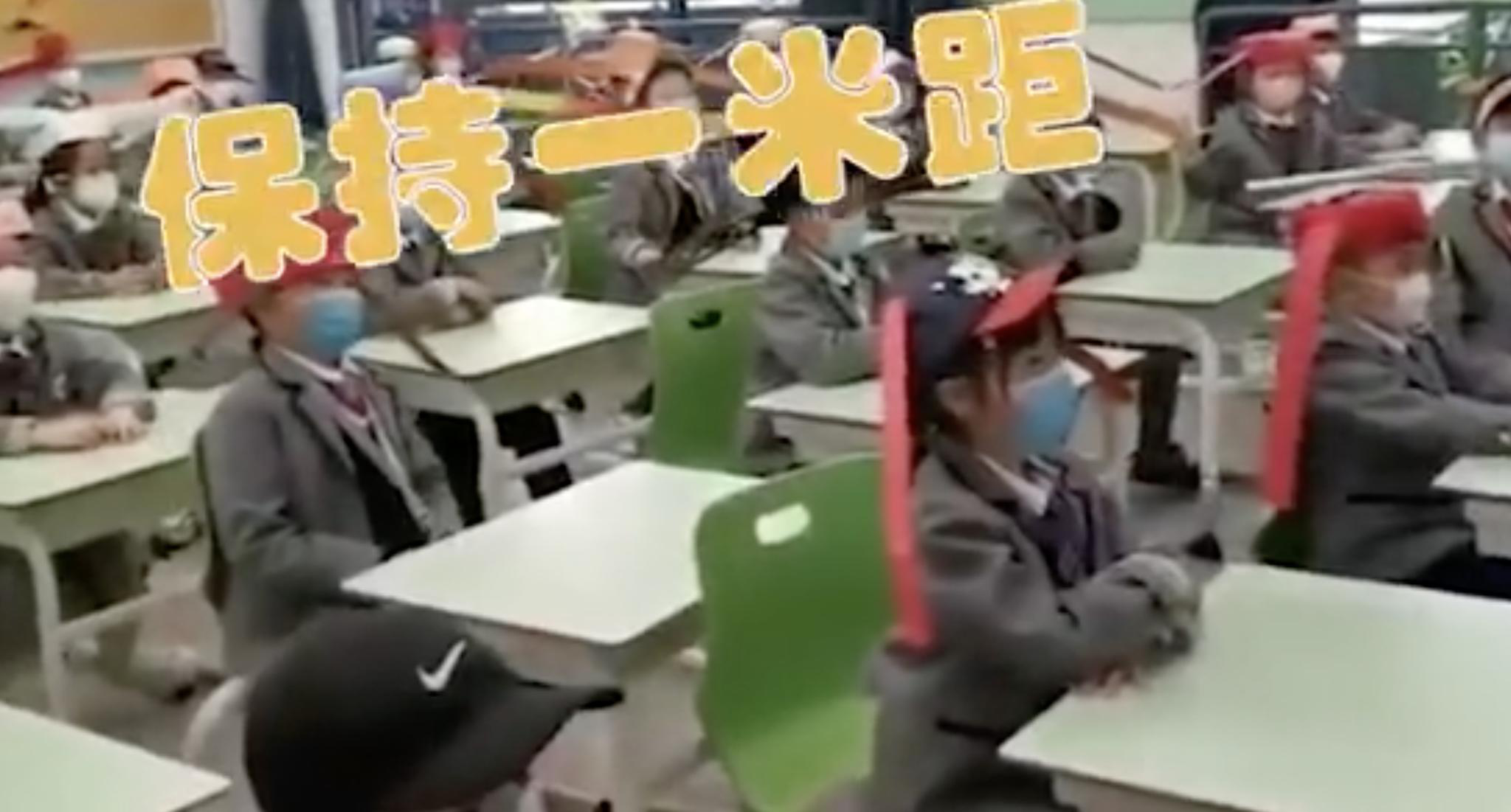 小学生为防疫戴“一米帽”上课 网友:清平乐少