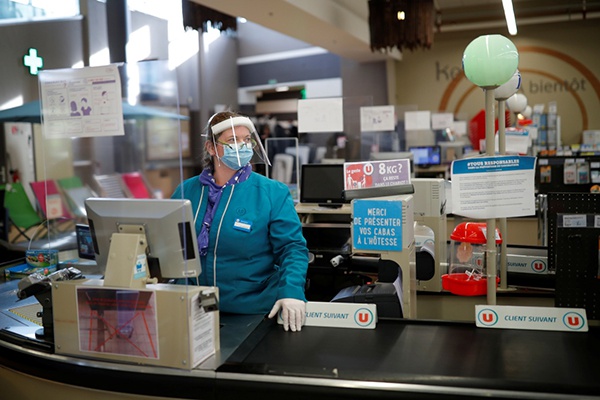 在法国布列塔尼大区，一名佩戴个人防护用具的收银员在超市工作。新华社 图