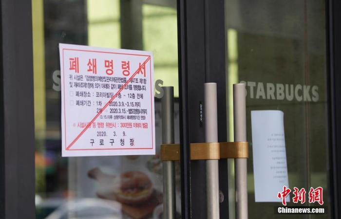 3月13日,首尔市九老区,引发集体感染的呼叫中心所在办公楼外张贴信息称,该楼1至12层封闭。中新社记者 曾鼐 摄